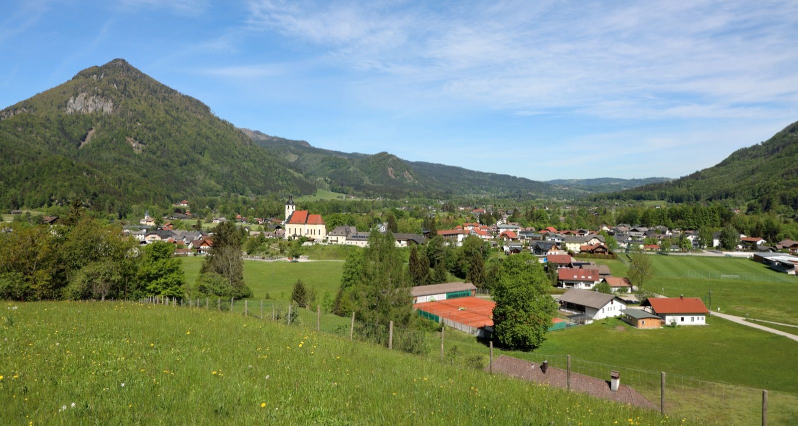 Grünau im Almtal mit der Pfarrkirche vor der Bergkulisse - das Herz des Almtals und Heimat von Wildpark und Graugans-Forschung.