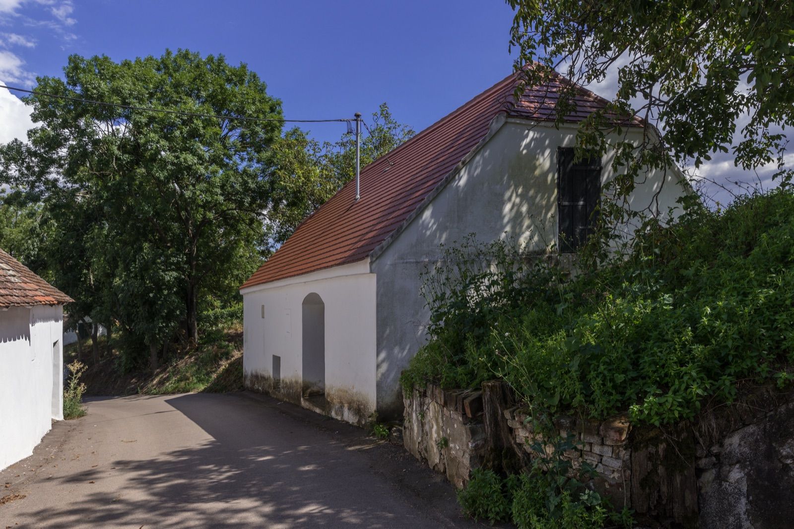 Weißes Presshaus an der Kellergasse Öhlberg in Pillersdorf, deren Weg die Weinradroute durch das Retzer Land begleitet.