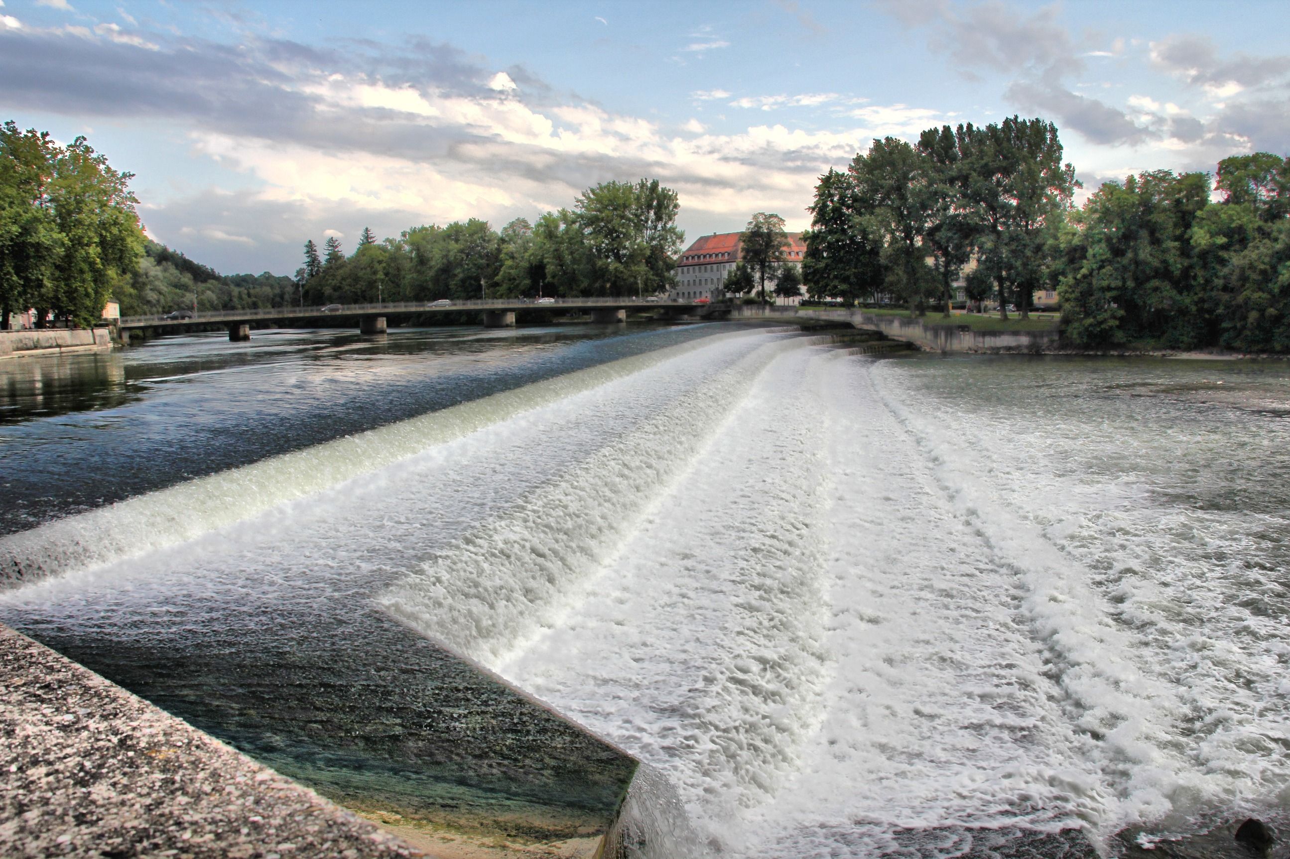 Das Lechwehr in Landsberg am Lech - in Bayern ist der Lech über weite Strecken reguliert; die spätgotische Altstadt mit dem Bayertor liegt hoch über dem Fluss.