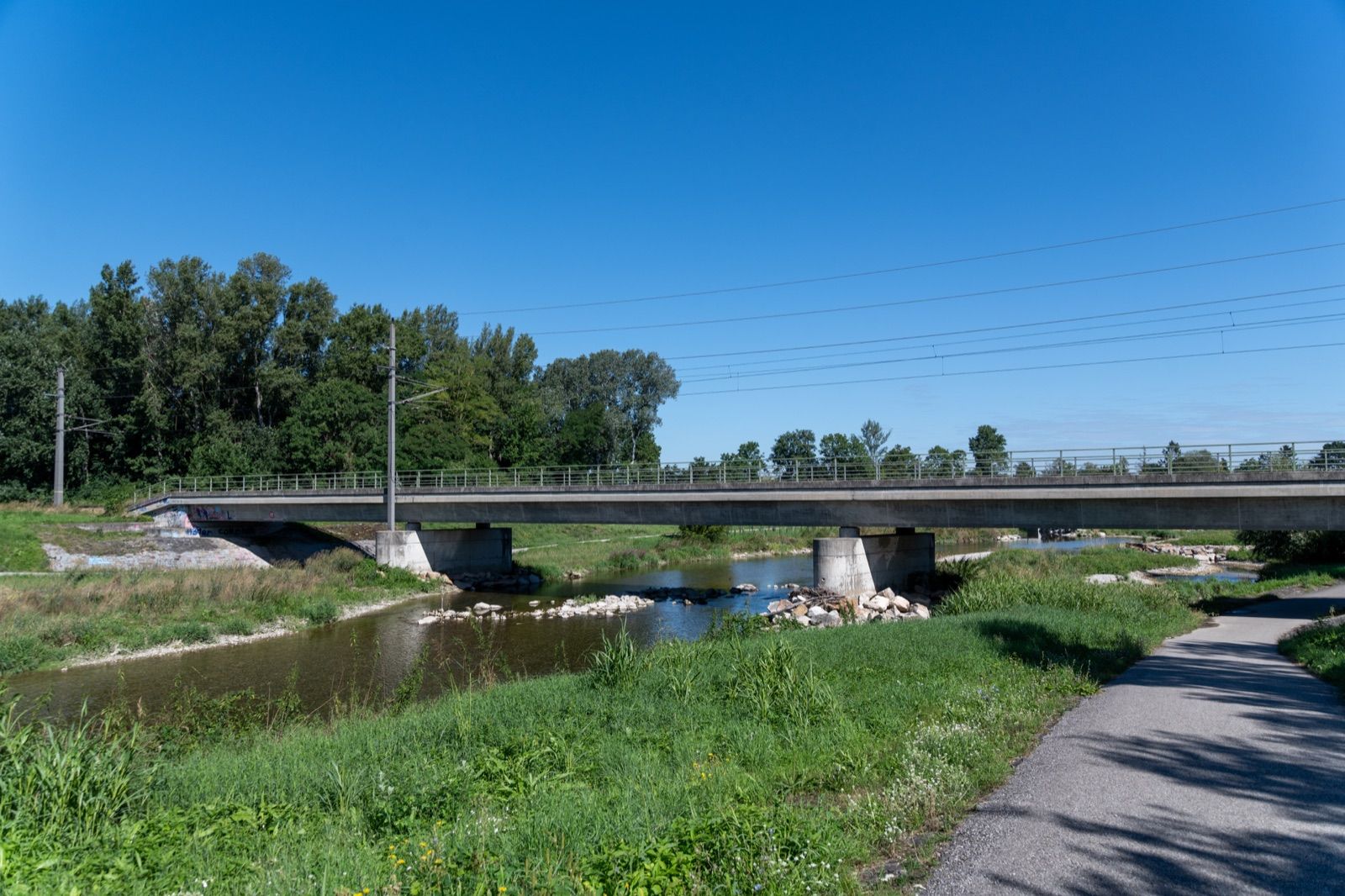 Asphaltierter Traisental-Radweg entlang der Traisen neben einer Brücke bei Traismauer