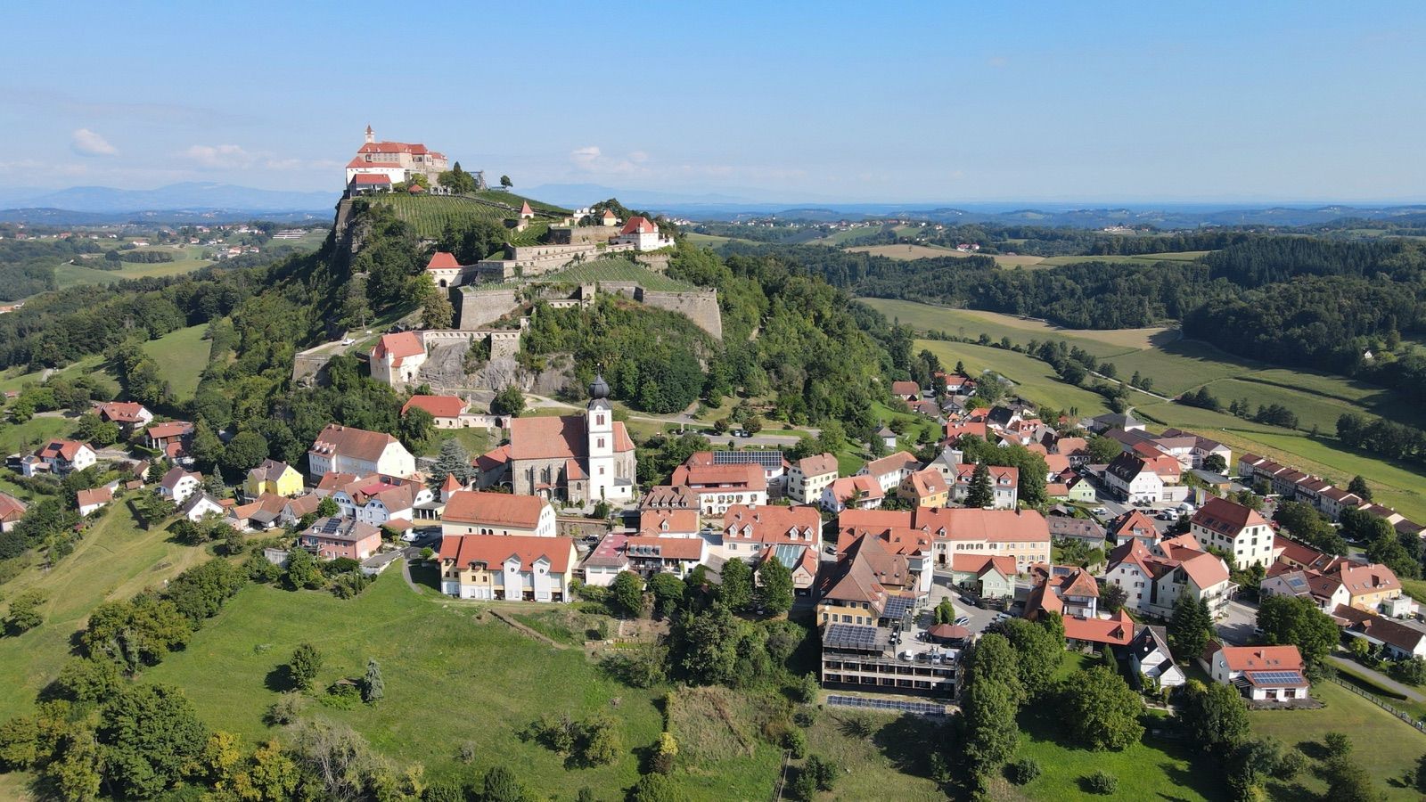 Die Burg Riegersburg auf ihrem Vulkanfelsen über dem Ort im oststeirischen Thermenland am Bernsteinradweg