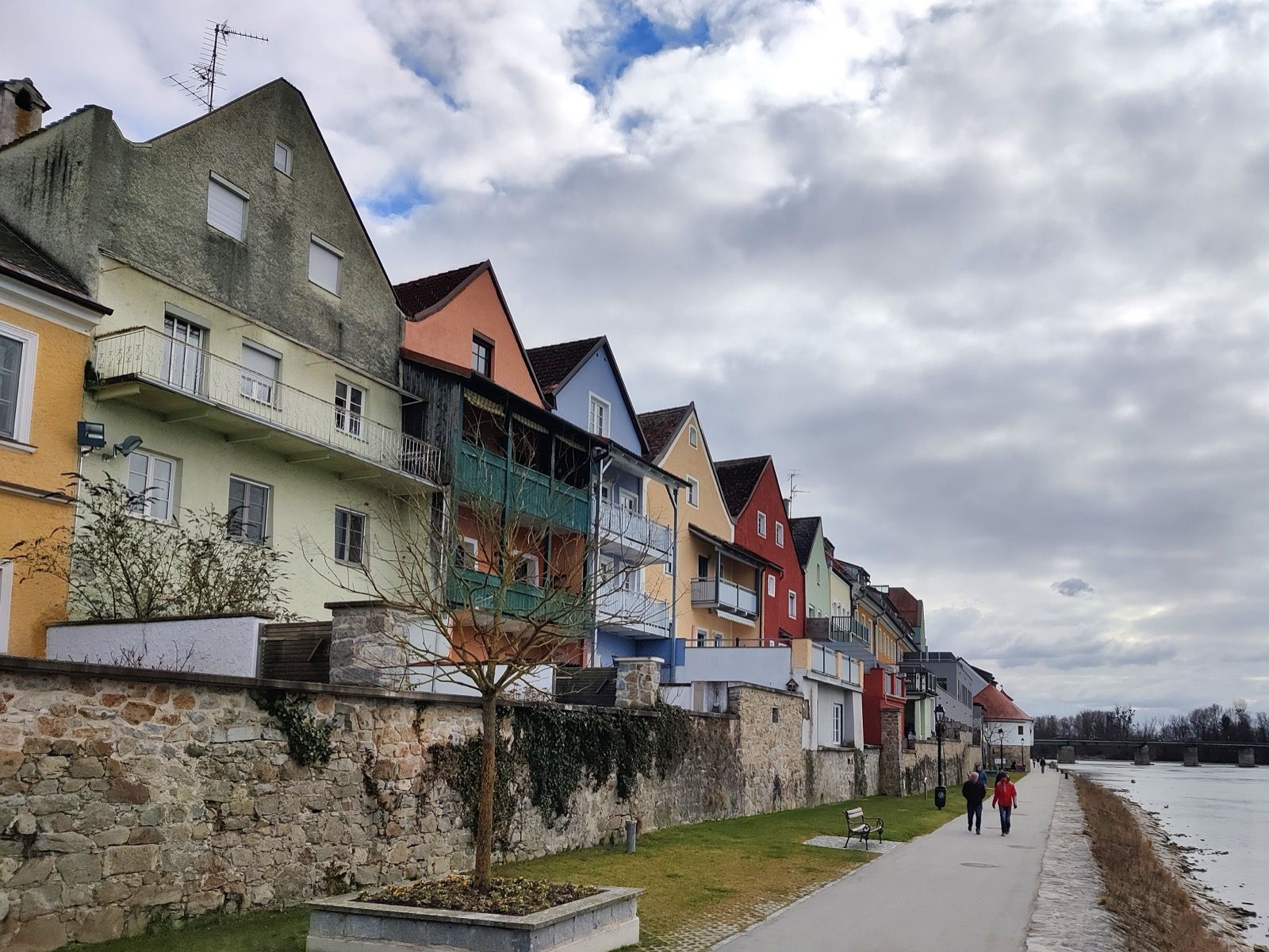 Die bunte Häuserzeile Schärdings über der Innlände - der Innweg führt am Fluss entlang unter der Barockstadt hindurch.
