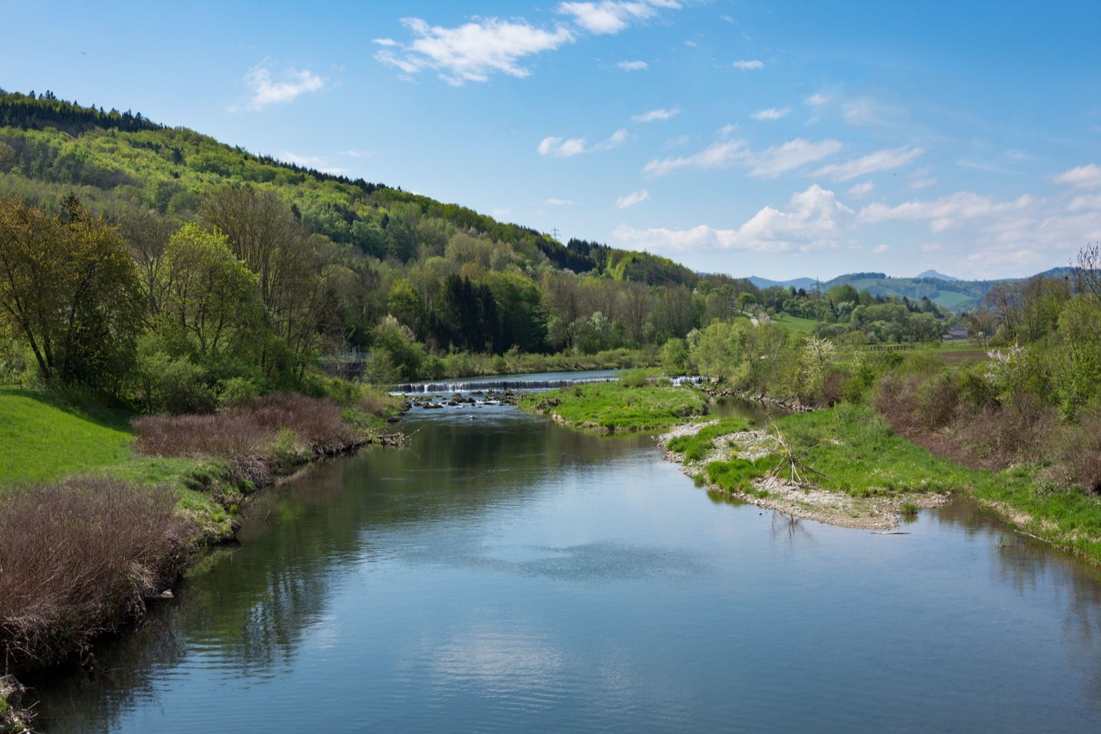 Die Traisen schlängelt sich durch das grüne Tal bei Wilhelmsburg mit bewaldeten Hängen