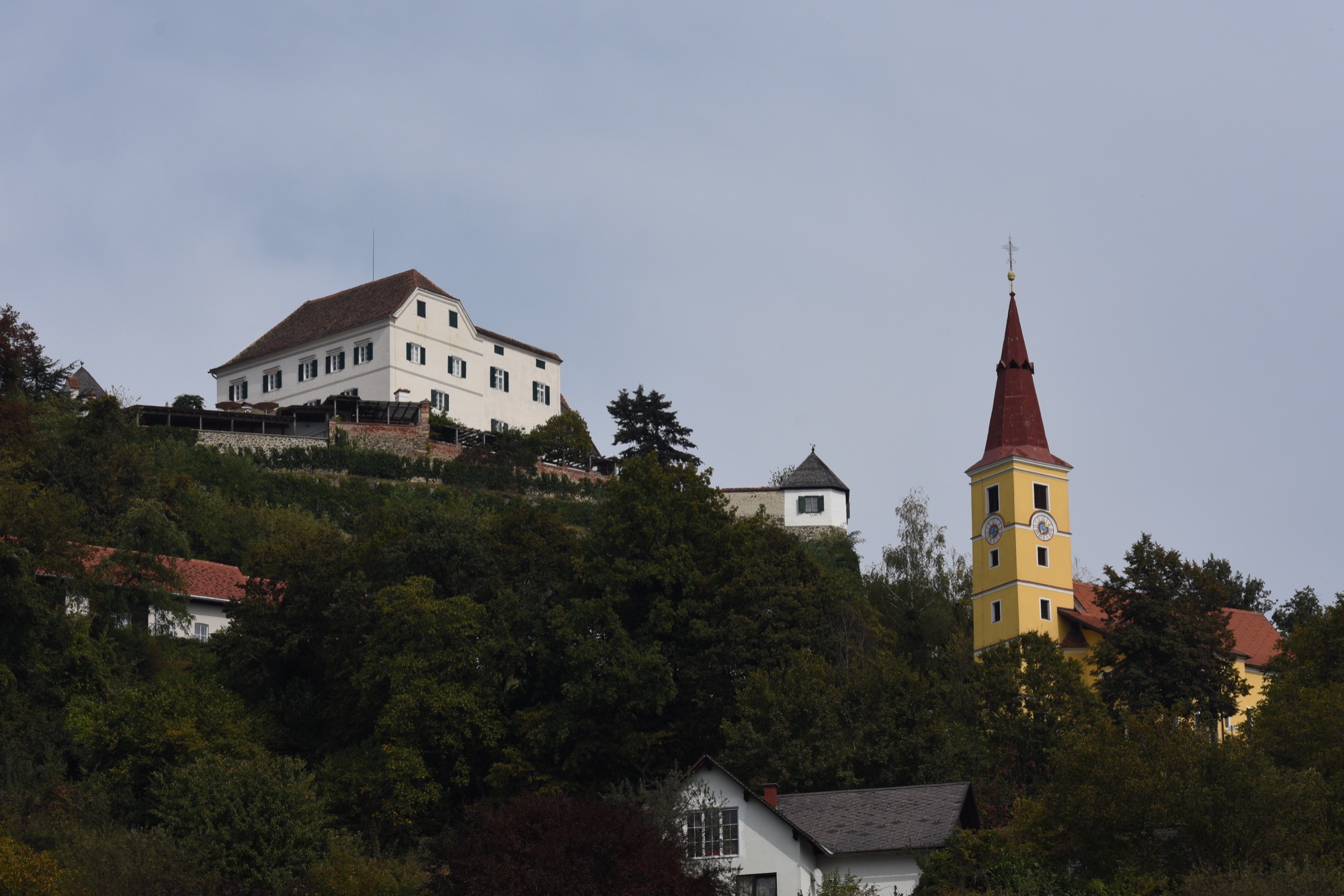 Schloss Kapfenstein und die Pfarrkirche auf einem erloschenen Vulkankegel über dem Hügelland